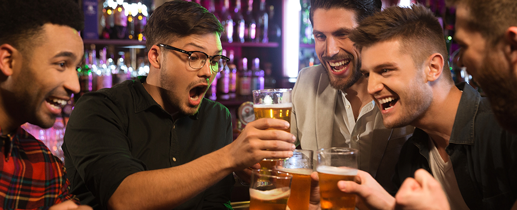 Friends drinking beer and watching football in Las Vegas.