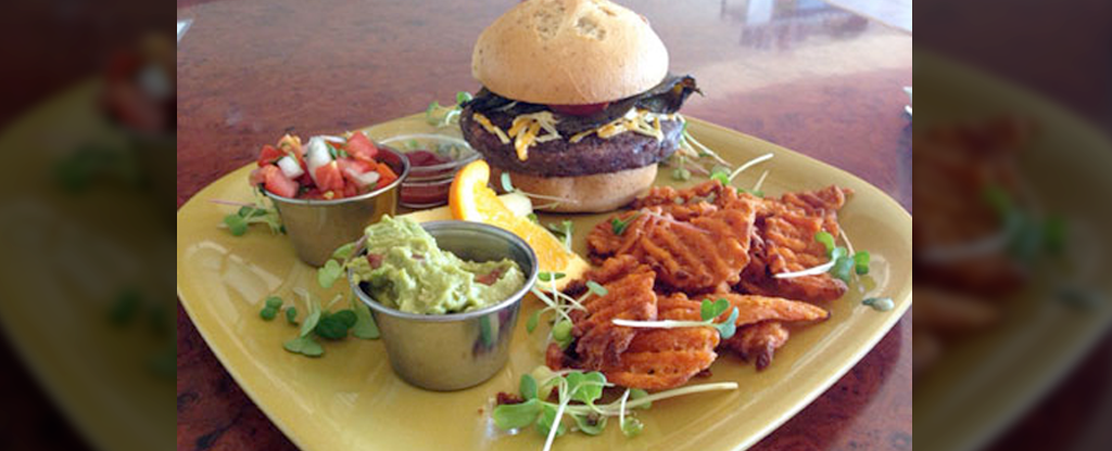 A vegan hamburger and waffle fries on a plate at Go Vegan Cafe in Las Vegas.