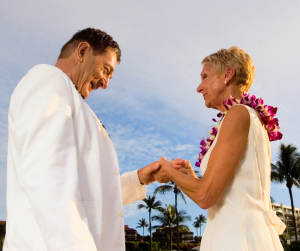Couple renewing their vows, wearing leis. 